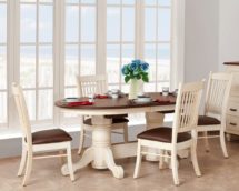 Staged Nantucket dining set with table and chairs with brown leather cushions.